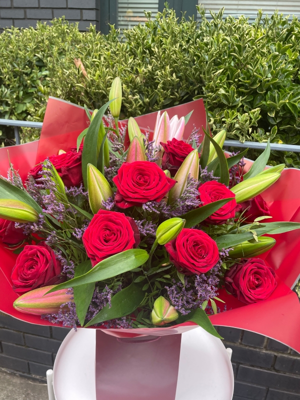 Red roses, limonium and lilies bouquet